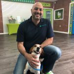 man kneeling with small brown and white dog
